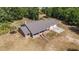 An expansive aerial view shows a single story brick home featuring an attached two-car garage amidst a lush wooded landscape at 5155 Holopaw Rd, St Cloud, FL 34773