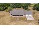 Expansive aerial view of a single story home with a brick exterior and a two-car garage surrounded by mature trees at 5155 Holopaw Rd, St Cloud, FL 34773