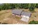 Aerial view of a brick home with a two-car garage, surrounded by trees and a partially fenced yard, offering a serene setting at 5155 Holopaw Rd, St Cloud, FL 34773