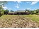 Extensive backyard showcasing the home's brick exterior, a large lawn, and a patio at 5155 Holopaw Rd, St Cloud, FL 34773