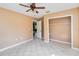 Bedroom with tiled floor and ceiling fan leading into a walk-in closet at 5155 Holopaw Rd, St Cloud, FL 34773