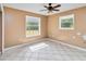 Inviting bedroom with tiled flooring, ceiling fan, and natural light from dual windows at 5155 Holopaw Rd, St Cloud, FL 34773