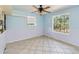 Cozy bedroom with a ceiling fan, and tiled floor with two bright windows at 5155 Holopaw Rd, St Cloud, FL 34773