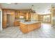 Bright kitchen with wooden cabinets, a large center island, and tile flooring, offering plenty of counter space at 5155 Holopaw Rd, St Cloud, FL 34773
