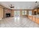 Open-concept living room with a brick fireplace, tile flooring, and doors leading to the outdoor area at 5155 Holopaw Rd, St Cloud, FL 34773