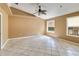 Spacious living room with ceiling fan, two windows, and neutral walls at 5155 Holopaw Rd, St Cloud, FL 34773