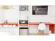 Modern hotel-style bedroom area with mini fridge, storage and red workstation desk at 5245 W Irlo Bronson Memorial Hwy # 113, Kissimmee, FL 34746