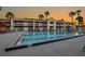Community pool with palm trees and ample seating against a backdrop of colorful sunset skies at 5245 W Irlo Bronson Memorial Hwy # 113, Kissimmee, FL 34746