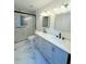 Updated bathroom with dual sinks, granite countertops, modern fixtures, and a walk-in shower at 5704 Sw 108Th St, Ocala, FL 34476