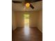 Cozy bedroom featuring wood floors and a ceiling fan with a view to the backyard at 6124 Fox Hunt Trl, Orlando, FL 32808