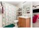 Bathroom with a single vanity, patterned shower curtain, and a decorative mirror at 709 Crystal Bay Ln, Orlando, FL 32828