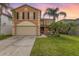 Charming two-story home with lush landscaping, palm trees, and a two-car garage at 709 Crystal Bay Ln, Orlando, FL 32828
