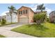 A two-story home featuring an attached garage, lush lawn, and mature palm trees, exuding curb appeal at 709 Crystal Bay Ln, Orlando, FL 32828