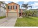 Charming two-story home featuring a large garage and well-maintained lawn with decorative palm trees at 709 Crystal Bay Ln, Orlando, FL 32828