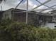 View of the backyard screened patio and mature landscape at 7406 Nolton Way, Orlando, FL 32822