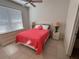 Bedroom featuring a large bed with lamps and tile flooring and a window with blinds at 8457 Secret Key Cove, Kissimmee, FL 34747