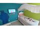 A brightly decorated bedroom with a single bed, colorful walls, and a TV at 8457 Secret Key Cove, Kissimmee, FL 34747