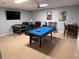 A spacious game room is equipped with a pool table, foosball, and a TV at 8457 Secret Key Cove, Kissimmee, FL 34747