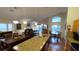 A spacious living room with a dining area, modern kitchen, and sliding glass doors to the pool area at 8457 Secret Key Cove, Kissimmee, FL 34747