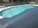 A large inviting pool with a unique shape is surrounded by a screened enclosure at 8457 Secret Key Cove, Kissimmee, FL 34747