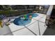 An outdoor screened pool with inflatable toys and a seating area is great for relaxation and entertainment at 8457 Secret Key Cove, Kissimmee, FL 34747
