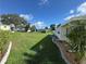 Wide backyard features a meticulously maintained lawn, decorative stone borders, and a view of neighboring homes at 102 Tangelo Cv, Leesburg, FL 34748