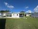 Lush backyard with a covered patio, landscaping, and ample space for outdoor enjoyment at 102 Tangelo Cv, Leesburg, FL 34748
