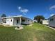 Spacious backyard with a covered patio, well-maintained lawn, and neighboring homes at 102 Tangelo Cv, Leesburg, FL 34748