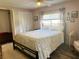 Comfortable bedroom featuring a bed with floral bedding, ceiling fan, and a window at 102 Tangelo Cv, Leesburg, FL 34748