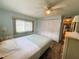 Bright bedroom with white closet doors and window with blinds, a ceiling fan, and wood laminate flooring at 102 Tangelo Cv, Leesburg, FL 34748