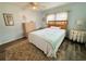Cozy bedroom featuring wood laminate flooring, a decorative rug, and natural light from a window at 102 Tangelo Cv, Leesburg, FL 34748