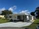 Inviting home with covered parking, lush landscaping, and a welcoming facade at 102 Tangelo Cv, Leesburg, FL 34748