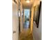 Hallway leading to bedroom with wood-look floors and neutral walls at 102 Tangelo Cv, Leesburg, FL 34748