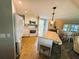 Open kitchen with white appliances, island with granite countertops, and adjacent dining area at 102 Tangelo Cv, Leesburg, FL 34748