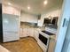 Bright kitchen featuring white cabinets, granite countertops, and stainless steel appliances at 102 Tangelo Cv, Leesburg, FL 34748
