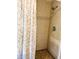 Bathroom with a tile shower featuring floral shower curtains and a modern shower head at 102 Tangelo Cv, Leesburg, FL 34748