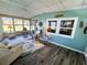 Bright sunroom features tile floor, ceiling fan, and windows with a comfortable seating area at 102 Tangelo Cv, Leesburg, FL 34748