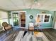 Bright sunroom with wood-look flooring, ceiling fan, and comfortable seating area at 102 Tangelo Cv, Leesburg, FL 34748