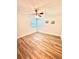 Bedroom with wood-look flooring, fan, and two windows providing natural light at 10529 Se 50Th Ave, Belleview, FL 34420