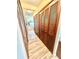 Hallway displaying wood-look floors, louvered closet doors, and an entryway to the kitchen area at 10529 Se 50Th Ave, Belleview, FL 34420