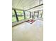 Enclosed sunroom with multiple windows, a ceiling with exposed beams, and a modern rug at 10529 Se 50Th Ave, Belleview, FL 34420