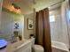 This bathroom features a single sink vanity with white cabinets and a shower with a curtain at 10640 Vista Del Sol Cir, Clermont, FL 34711