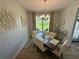 Dining area with seating for six, featuring a modern chandelier and a view of the landscaped front yard at 10640 Vista Del Sol Cir, Clermont, FL 34711