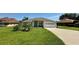 Inviting single-story home with lush green lawn, landscaped front yard, and neutral color palette at 10640 Vista Del Sol Cir, Clermont, FL 34711
