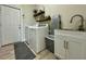 Functional laundry room with sink, washer, dryer, shelving, and ample storage space at 10640 Vista Del Sol Cir, Clermont, FL 34711