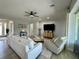 Comfortable living room with a white sofa, ceiling fan, large TV, and ample natural light at 10640 Vista Del Sol Cir, Clermont, FL 34711