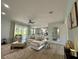 Bright living room featuring a white sofa, modern decor, ceiling fan, and large windows with backyard views at 10640 Vista Del Sol Cir, Clermont, FL 34711