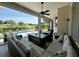 Comfortable covered patio with wicker furniture overlooking the pool, green lawn, and manicured landscaping at 10640 Vista Del Sol Cir, Clermont, FL 34711