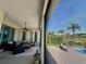 Relaxing covered patio with wicker furniture, ceiling fan, pool view, and view of green landscaping at 10640 Vista Del Sol Cir, Clermont, FL 34711