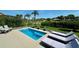 A tranquil pool surrounded by lush landscaping, lounge chairs, and ample space for relaxation and outdoor enjoyment at 10640 Vista Del Sol Cir, Clermont, FL 34711